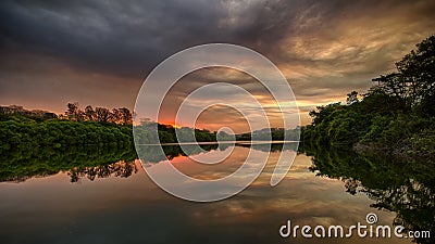 Sunset on the lake with trees around Stock Photo