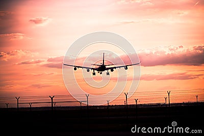 Sunset with landing airplane Stock Photo