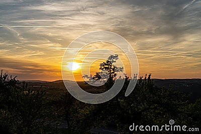 Sunset and landscape with fields, hills and golden light Stock Photo