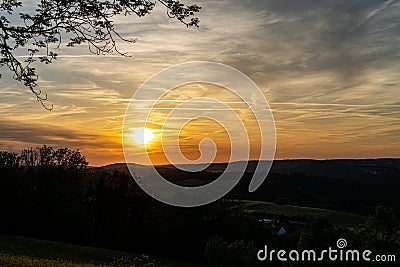 Sunset and landscape with fields, hills and golden light Stock Photo
