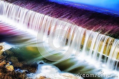 Sunset landscape next to a waterfall in a forest. Stock Photo