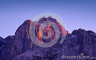 Sunset light on Jof Fuart peak from Valbruna town. Stock Photo