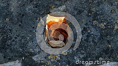 Sunset light penetrates through a square hole in an old stone Stock Photo