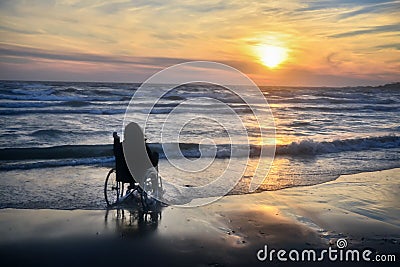 Sunset, makes sightseeing on the beach a woman on a wheelchair Stock Photo