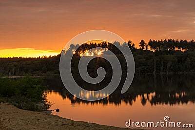 Sunset at the Mechelse Heide ith a scenic view of being on the beach with sand and water and hard shadows of rocks Stock Photo