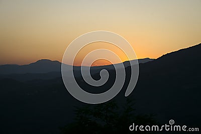 Sunset on the mountains, orange sky and dark mountain Stock Photo