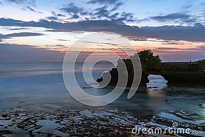 Sunset near famous tourist landmark of Bali island - Tanah Lot & Batu Bolong temple. Stock Photo