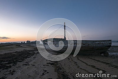Sunset and old shipwreck in Arz Island in Brittany Morbihan, F Stock Photo