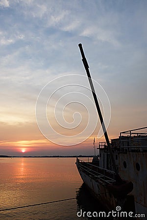 Sunset and old warship at estuary Stock Photo