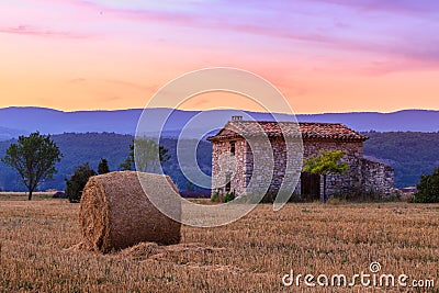 Sunset over farm field with hay bales near Sault Stock Photo