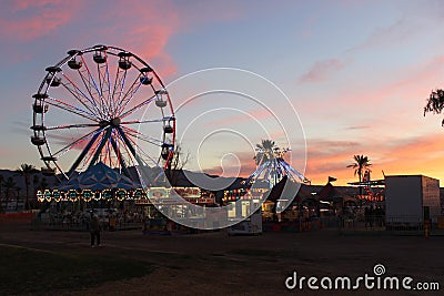 Sunset over Ferris Wheel and Carnival Rides Stock Photo