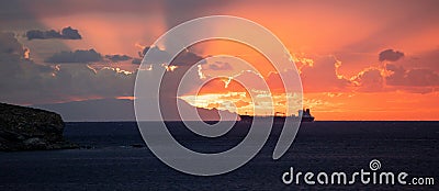 Sunset over Greek island Cyclades. Colorful sky cloud silhouette of line ship dark blue sea. Banner Stock Photo