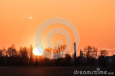 Sunset over the industrial zone, moon. Stock Photo