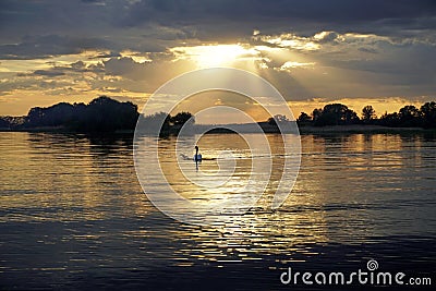 Sunset over the lake on a warm summer day. June sky and beautiful clouds. Horizon and reflection. Stock Photo