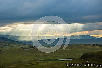 Sunset over the mountain landscape. A beautiful sun rays with clouds. Republic Of Khakassia, Russia. Stock Photo