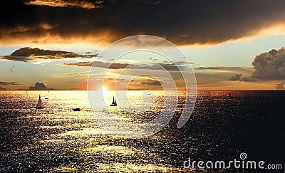 Sunset over the sea with boats Stock Photo