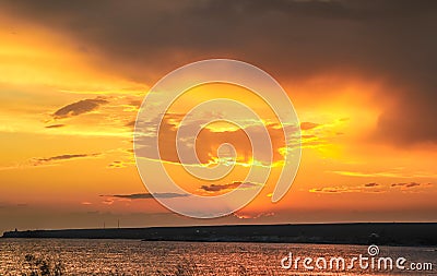 Sunset over the sea in yellow, beige, brown, pink colors. Stock Photo