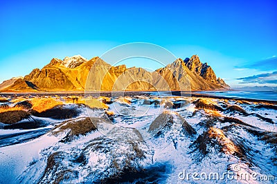 Sunset over the Stokksnes Mountain on Vestrahorn Cape with Snow in Iceland Stock Photo