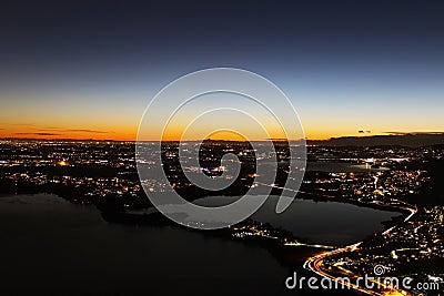 Sunset panorama over northern Lombardy lakes showing light pollution and Alps sihouette in the background Stock Photo
