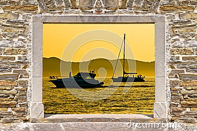 Sunset sailing and yachting through stone wall door Stock Photo