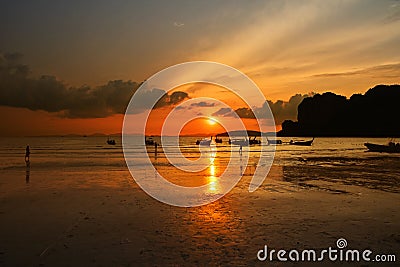 Sunset sea beach with long tail boat silhouettes Stock Photo