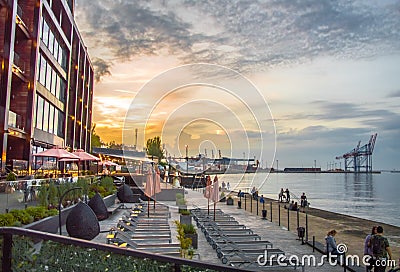 Sunset by the sea. Beautiful buildings and the port Editorial Stock Photo