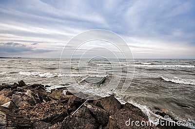 Sunset at the sea shore of a beach with rocks and stormy waves, beautiful seascape at Caspian sea Absheron, Azerbaijan Novkhani Stock Photo