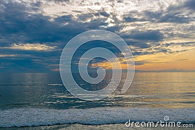 Sunset seascape, orange, blue, yellow sky, with aqua marine green sea, white waves rolling in, pacific ocean, background photo of Stock Photo