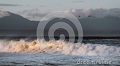 Sunset Seascape. Powerful ocean wave on the surface of the ocean. Wave breaks on a shallow bank. Stormy weather, stormy clouds sky Stock Photo