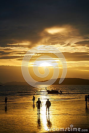 Sunset on the seashore.People are looking for beautiful shells on the bottom at low tide Editorial Stock Photo