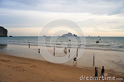 Sunset on the seashore.People are looking for beautiful shells on the bottom at low tide Editorial Stock Photo