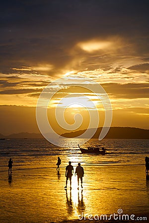 Sunset on the seashore.People are looking for beautiful shells on the bottom at low tide Stock Photo