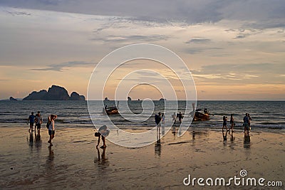 Sunset on the seashore.People are looking for beautiful shells on the bottom at low tide Editorial Stock Photo