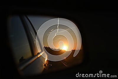 Sunset in the side mirror, darkness in road traffic Stock Photo