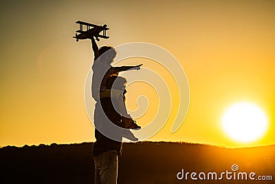 Sunset silhouette of child and dad playing. Kid pilot aviator and daddy dreams of traveling. Happy boy child. Stock Photo