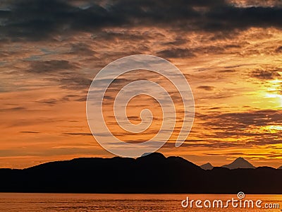 Sunset and silhouette distant hills and land in Alaska Stock Photo