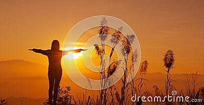 Sunset silhouette Young woman feeling to Freedom and Relax Stock Photo