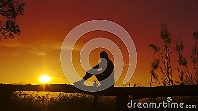 Sunset silhouette Young woman sad Stock Photo