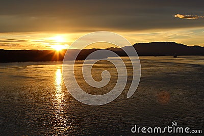 Sunset silhouettes Canadian islands and sun glittering off the water Stock Photo