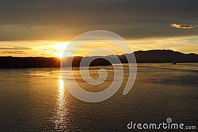 Sunset silhouettes Canadian islands and sun glittering off the water Stock Photo