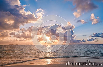Sunset sky with colorful clouds over ocean and beach Stock Photo