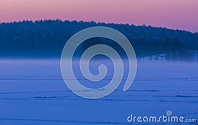 Sunset sky over frozen and snowy lake. Stock Photo