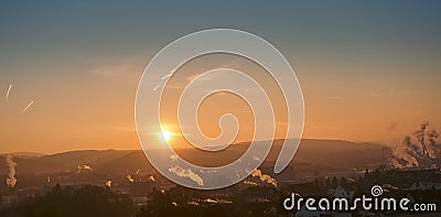 Sunset with smoke and condensation trails Stock Photo