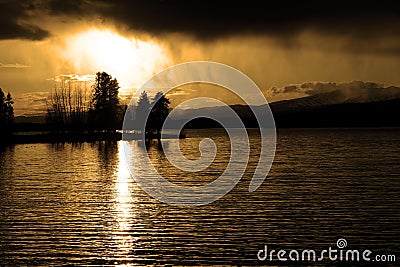 Sunset Storm Clouds Over Lake Pine Trees Wilderness Stock Photo