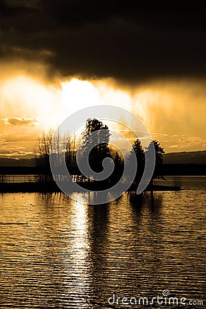 Sunset Storm Clouds Over Lake Pine Trees Wilderness Stock Photo