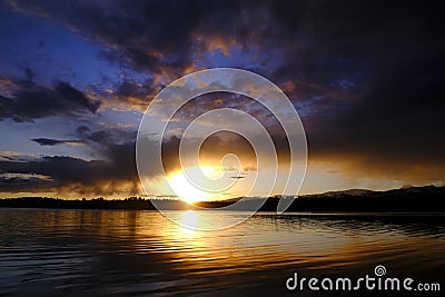 Sunset Storm Clouds Over Lake Pine Trees Wilderness Stock Photo