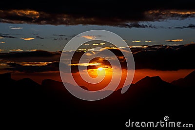 Sunset. The sun above the line of mountains Stock Photo