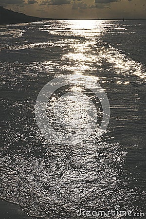 Sunset - sun reflecting in waves, shore Stock Photo