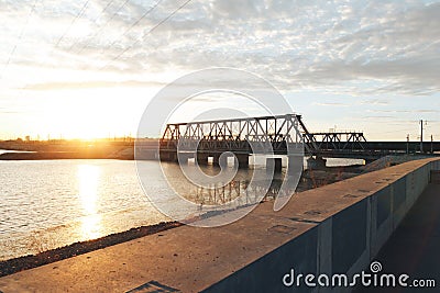The sunset train passes the railway bridge Stock Photo