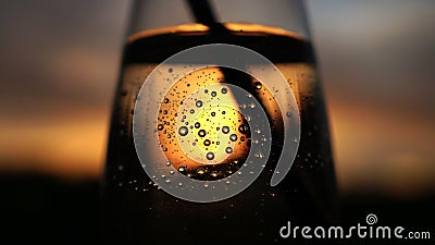 Sunset twilight shines shining past through clear transparent vase bowl glass cup water bubbles Stock Photo